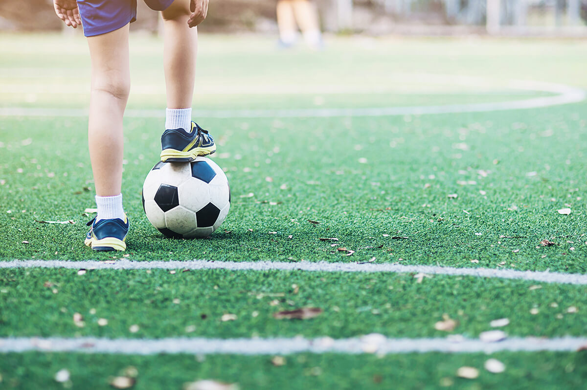 Chłopiec z piłką na boisku szkolnym - badania dzieci idących do klas sportowych