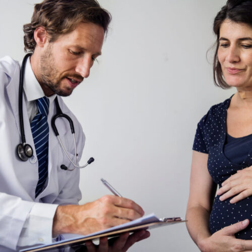 Kobieta w ciąży rozmawia z ginekologiem. Cesarskie cięcie - jak się do niego przygotować?