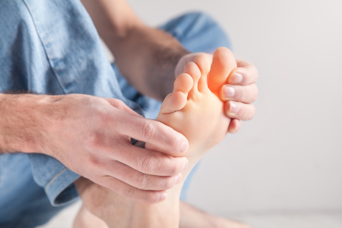 Mężczyzna trzymający się za stopę. Choroby stóp - o czym może świadczyć ból, swędzenie lub obrzęk?