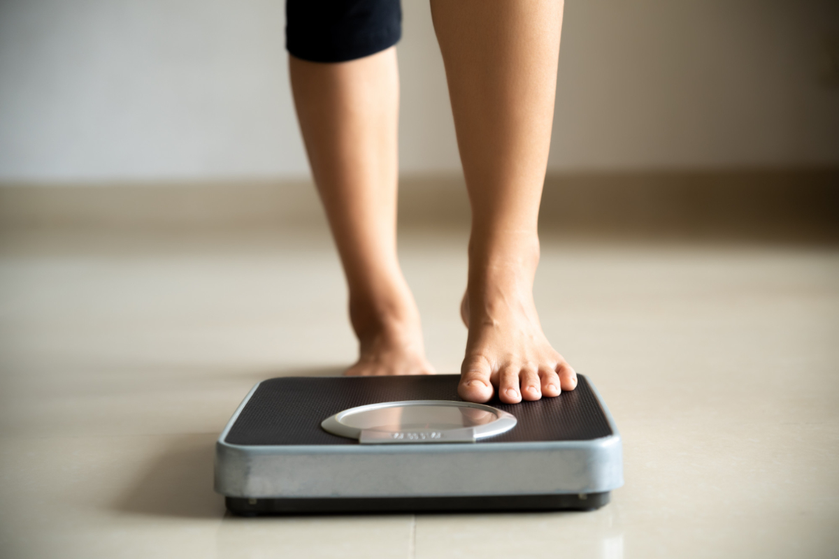 Kobieta staje na wadze. Jak zapobiegać otyłości