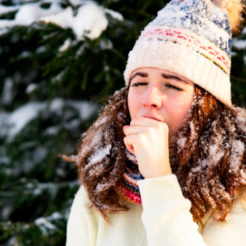 Dziewczyna kaszle w lesie Alergia zima