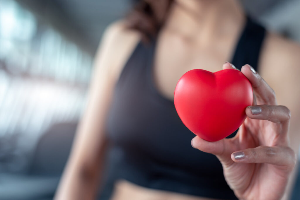 Gumowe serce w dłoni kobiety na siłowni. Profilaktyka serca - zadbaj o nie przed wiosną