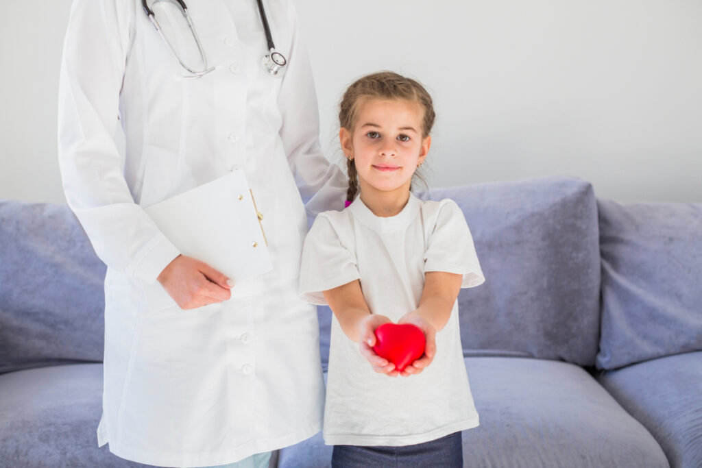 Dziewczynka z kardiologiem i sercem w dłoni. Jak dbać o serce małego sportowca