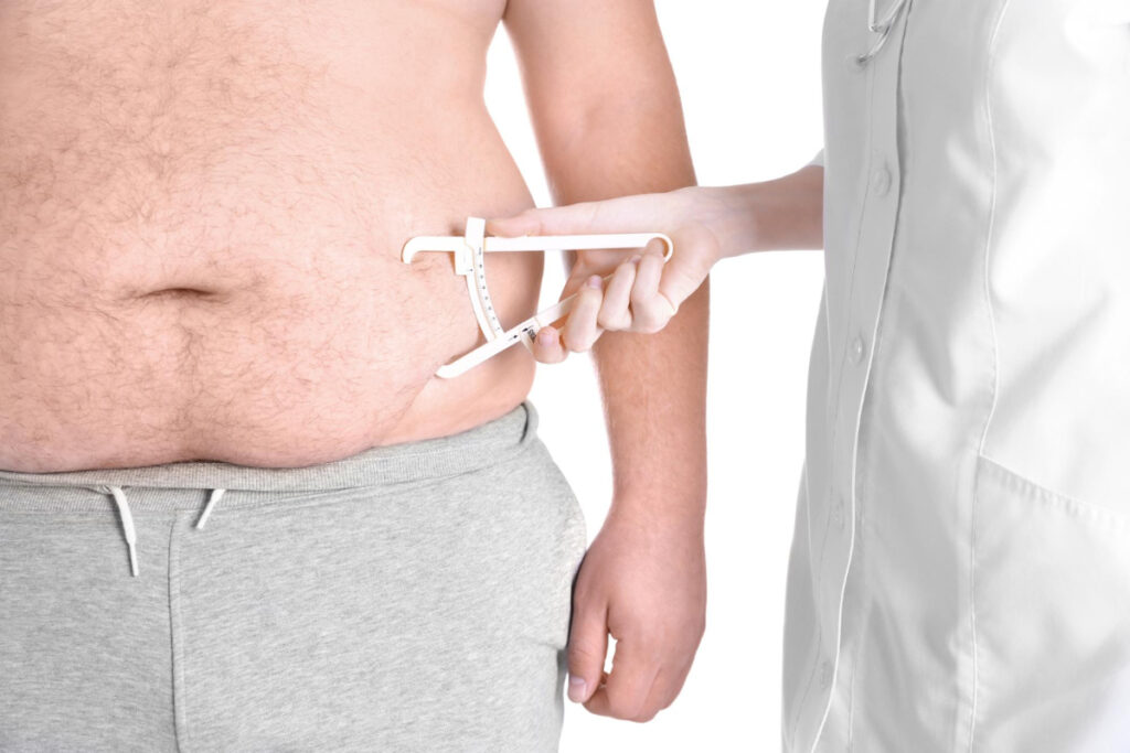Dietetyk mierzy tkankę tłuszczową u osoby otyłej. Kobieta u dietetyka klinicznego. Kim jest dietetyk kliniczny