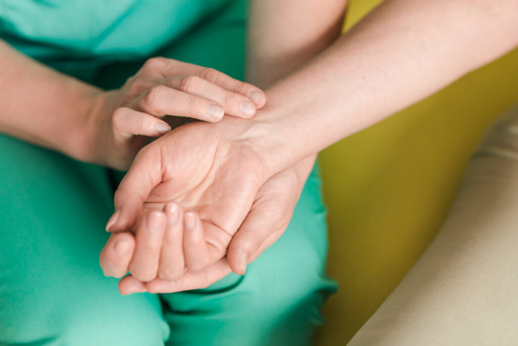 Lekarka diagnozuje przykurcz dłoni u pacjentki
