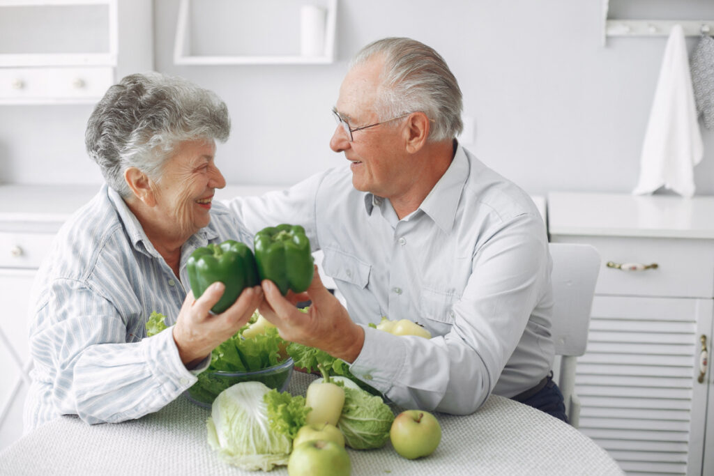 Para seniorów przy stole z warzywami - leczenie dietą przy osteoporozie