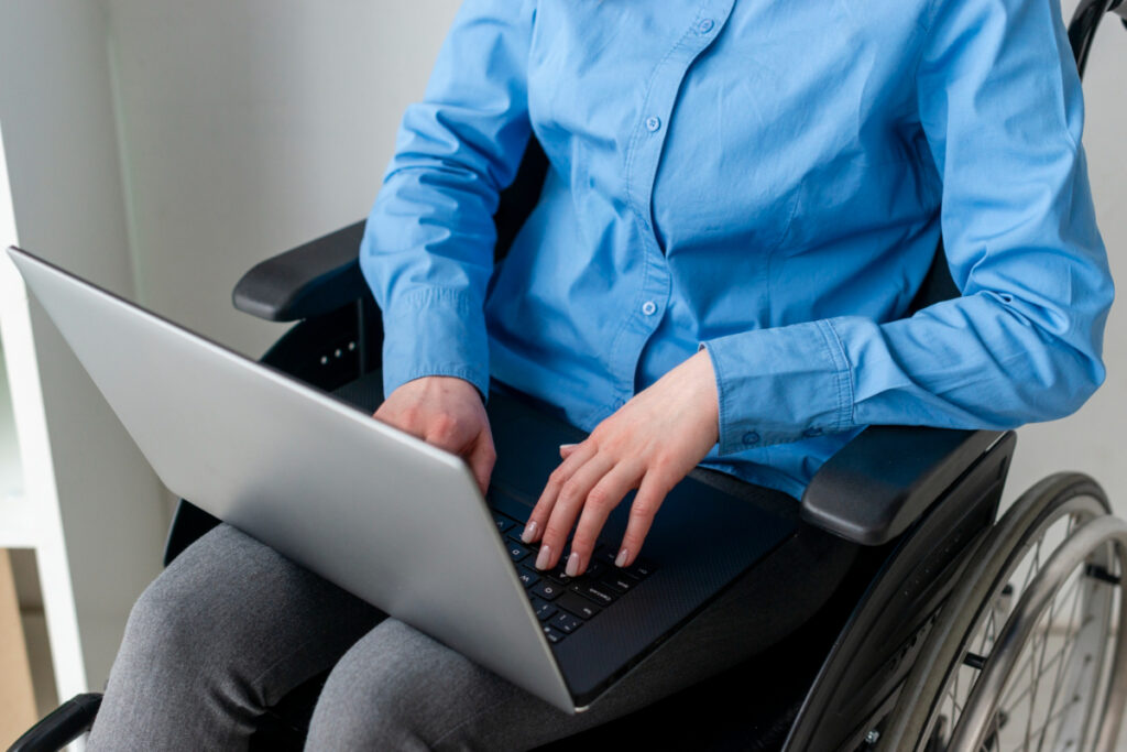 Mężczyzna na wózku inwalidzkim z laptopem. Pomoc psychologiczna online