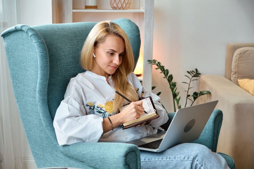 Kobieta na fotelu z laptopem na kolanach. Skuteczność psychoterapii zdalnej