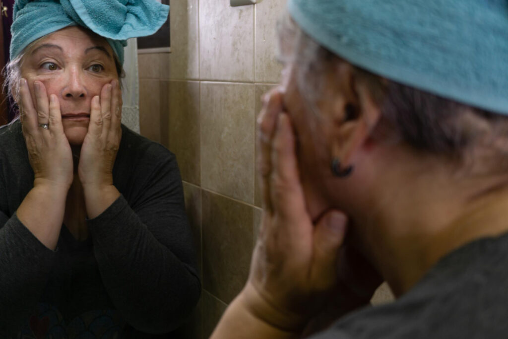 Kobieta po 40 roku życia przegląda się w lustrze