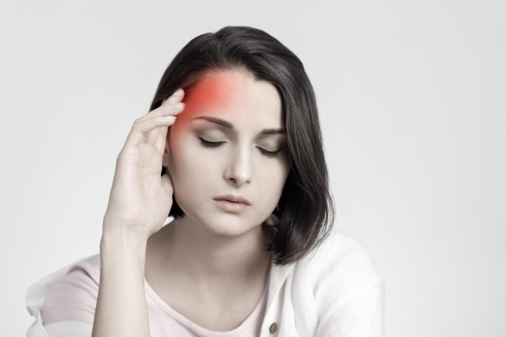 Kobieta z migreną trzyma dłoń przy skroni