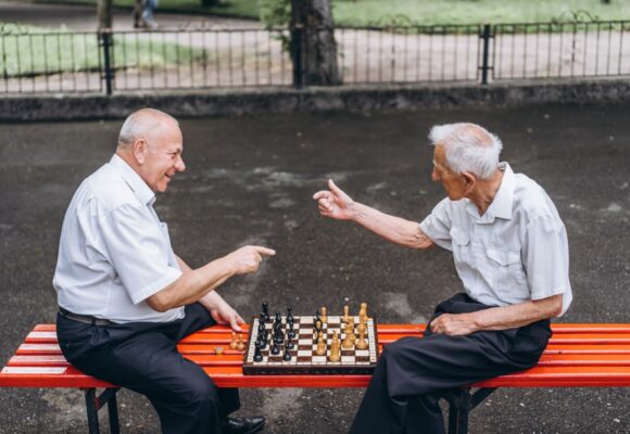 Seniorzy grają w szachy w parku. Psychiatra dla seniorów — kiedy warto skorzystać z tego rodzaju wsparcia