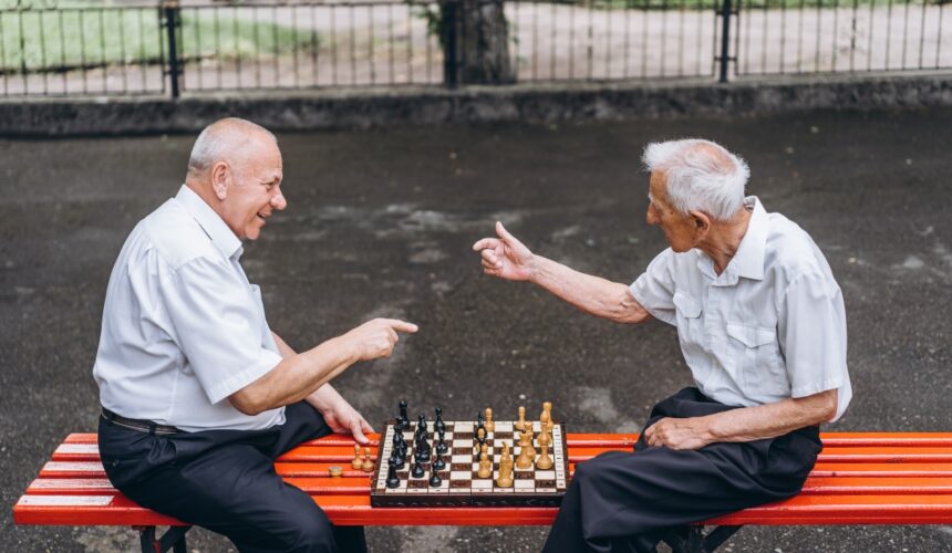 Seniorzy grają w szachy w parku. Psychiatra dla seniorów — kiedy warto skorzystać z tego rodzaju wsparcia