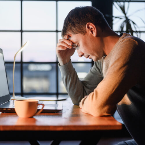 Zmęczona pracą kobieta przy laptopie . Wypalenie zawodowe